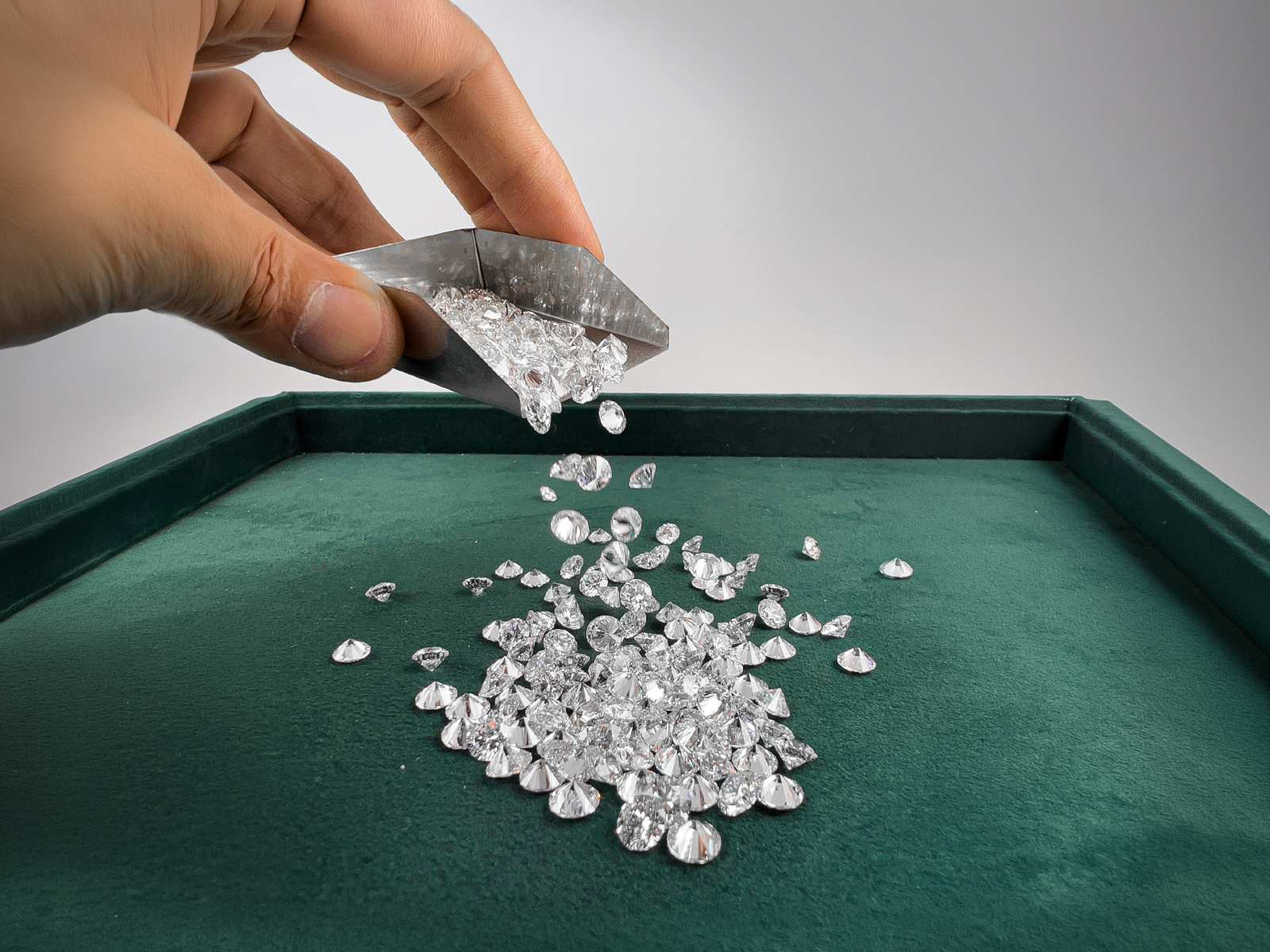 Loose polished lab-grown diamonds poured onto a grading tray