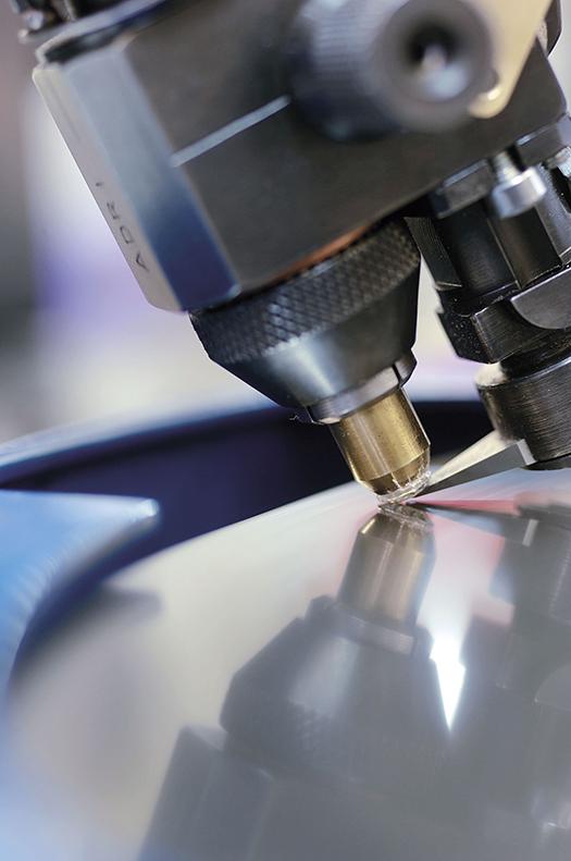 A technician examining a lab-grown diamond under a gemological microscope